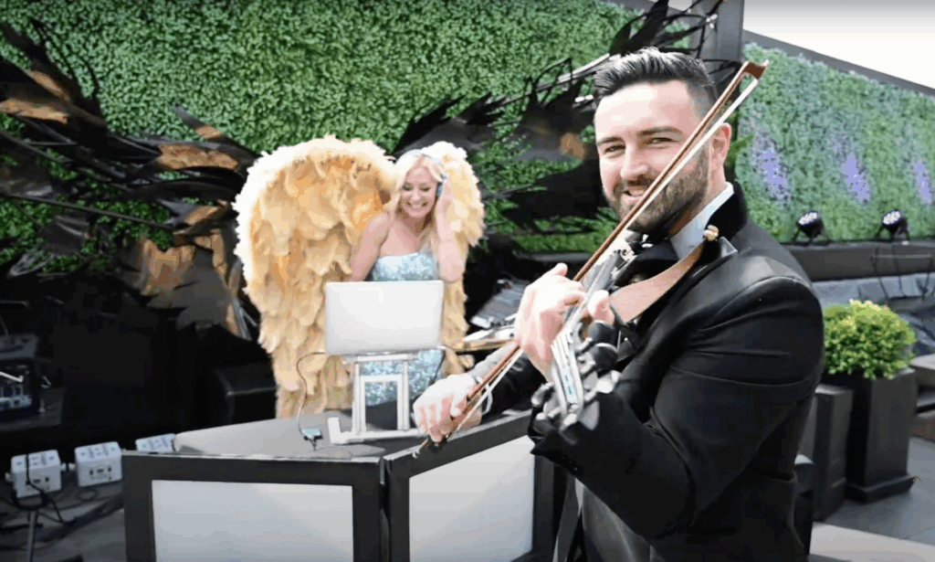 DeeJay Shelly in gold wings performing with Alexandr Kislitsyn on electric violin at Stratus Rooftop Lounge in Philadelphia, PA.