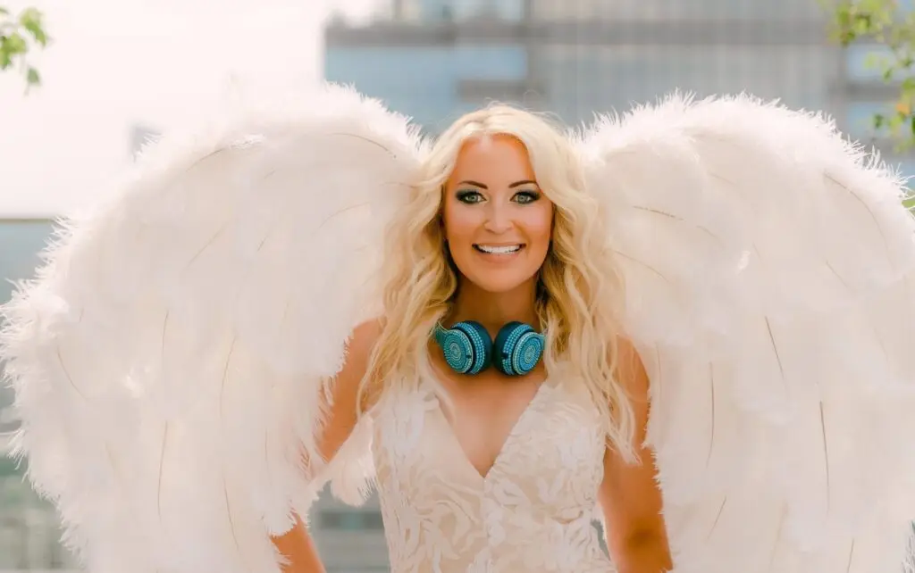 DeeJay Shelly wearing her signature white wings and turquoise rhinestone headphones – female DJ entertainer based in Philadelphia